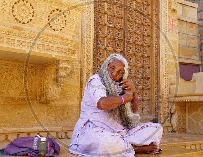 Indian old woman combing her hair