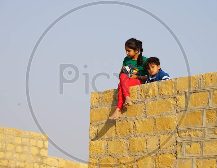 View of Indian kids sitting on the wall