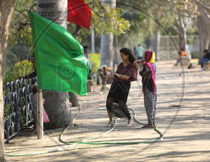 An Indian Mother Taking Pictures of Her Daughter At an Outdoor Background