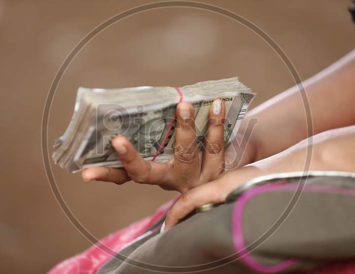 An Woman Holding  Indian Currency Bundle
