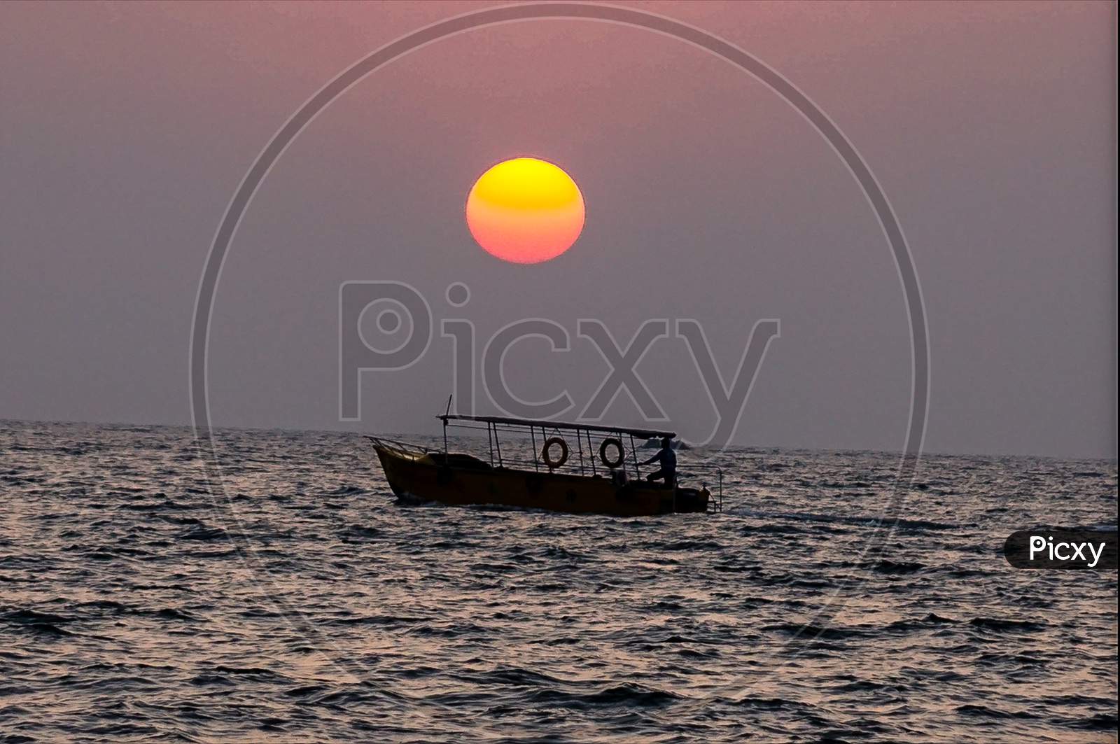 A boat sailing in sea with beautiful sunset in the background