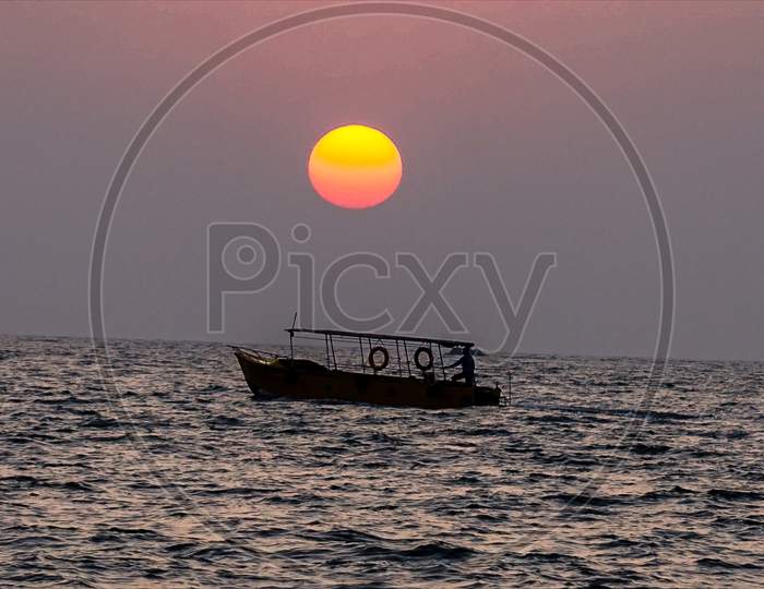 A boat sailing in sea with beautiful sunset in the background