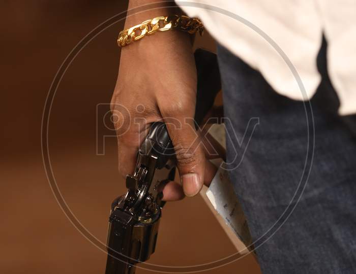 A Man Holding  Pistol Or Gun Or Revolver in hand Closeup