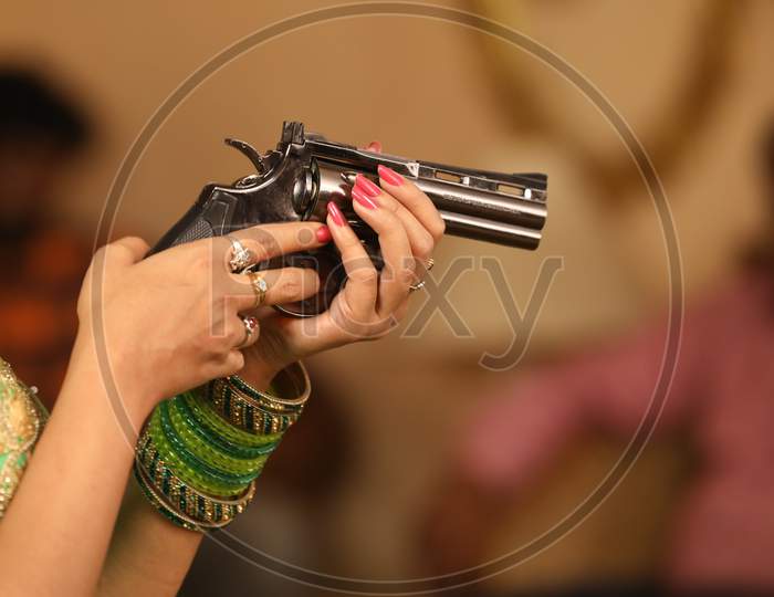 Indian Young Woman Holding Gun or Pistol Or Revolver In hand Closeup