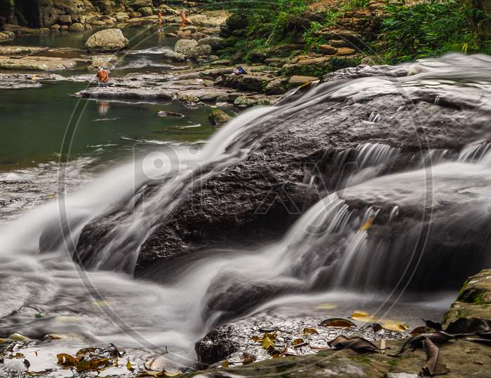 Long exposure shot of water stream along the rock body