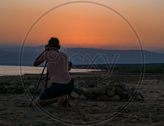 Photographer photographing sunset at Dead Sea