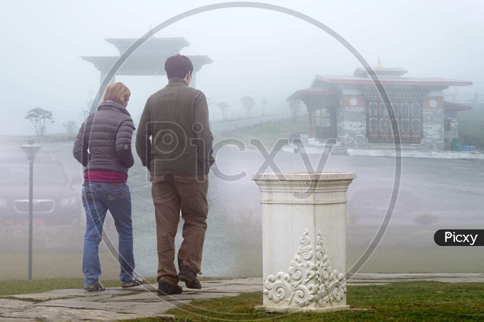 A Couple walking along the roadway covered with fog