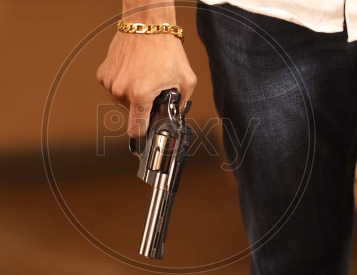 Man Holding Pistol or Gun Or Revolver In Hand Closeup