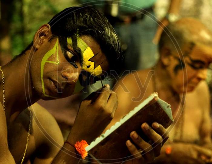 Indian man putting yellow face paint
