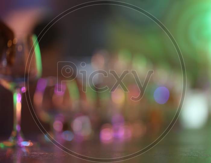 Wine Glasses At a Bar Counter With Neon Lights Flare