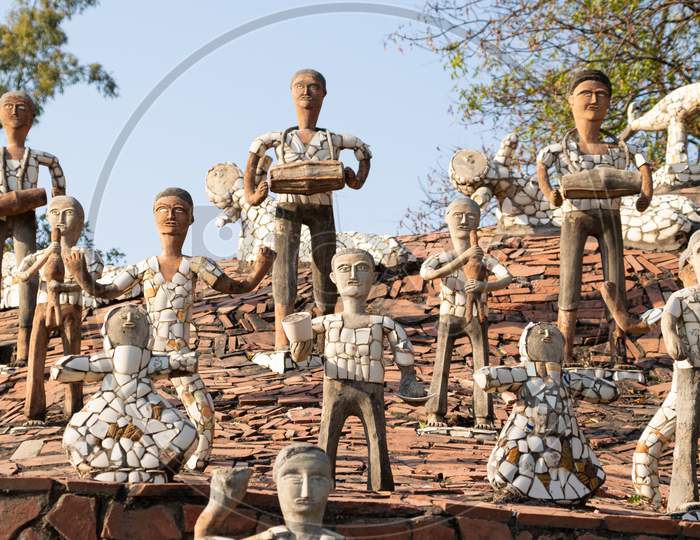 sculptures of men and women decorated with broken tiles at rock garden chandigarh