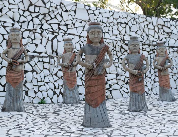 sculptures of women and decorated surface of broken tiles at rock garden chandigarh