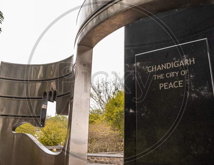 A structure made near sukhna lake consisting open hand and a text "Chandigarh the city of peace"