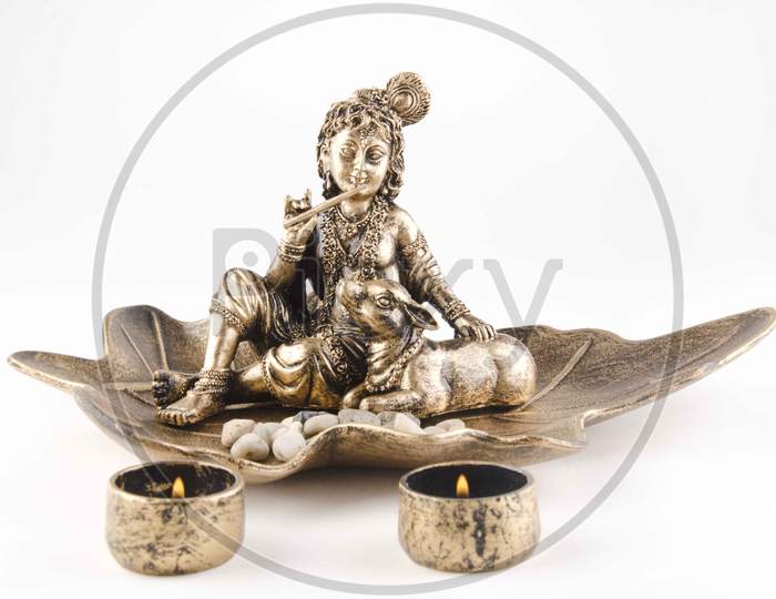 Brass Idol Of Lord Krishna Over An Isolated White Background