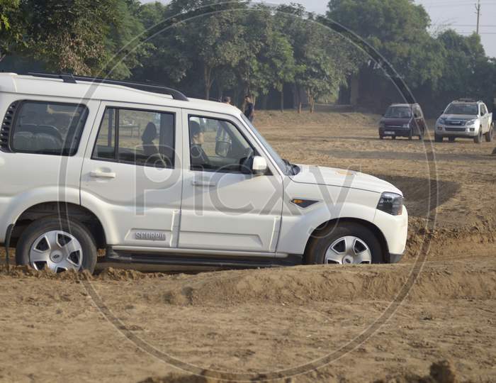 Side view of Mahindra Scorpio Car moving the bumps of dirt road