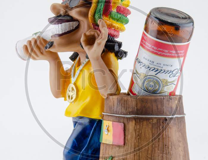 Action Figure or A Toy With Budwiser Pint in Things Holder Over an Isolated White Background