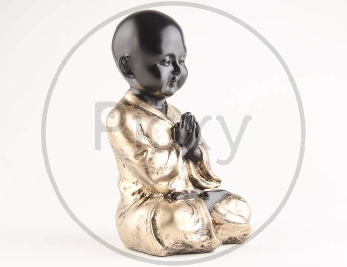 Chinese Boy Statue With Namaste Gesture Over An Isolated White Background