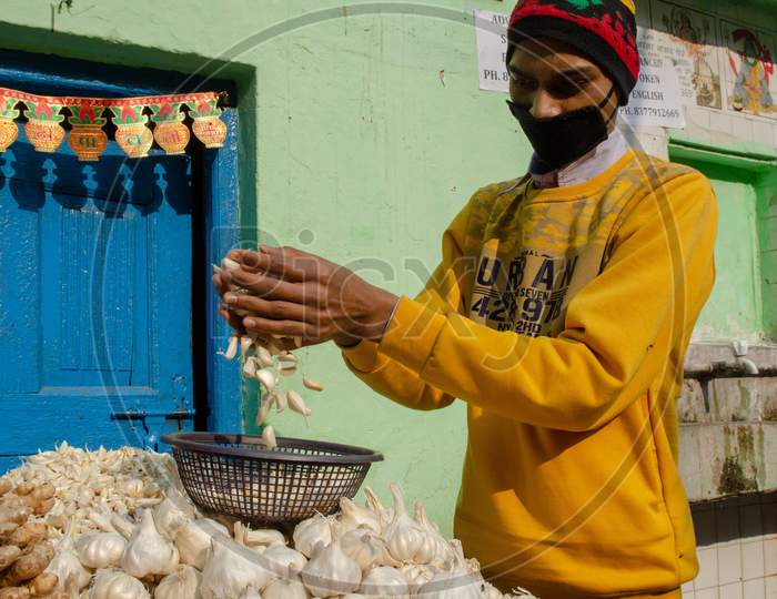 A Vendor Selling Garlic And Ginger At a Market