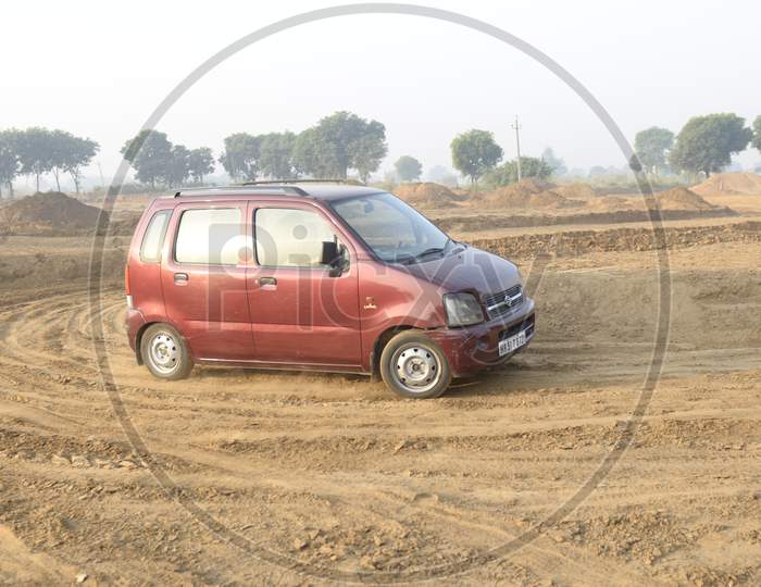Maruti Suzuki Wagon R moving along the dirt road