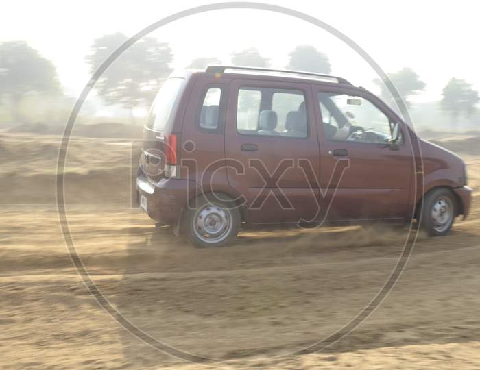 View of A Maruti Suzuki Wagon R Car moving through the mud