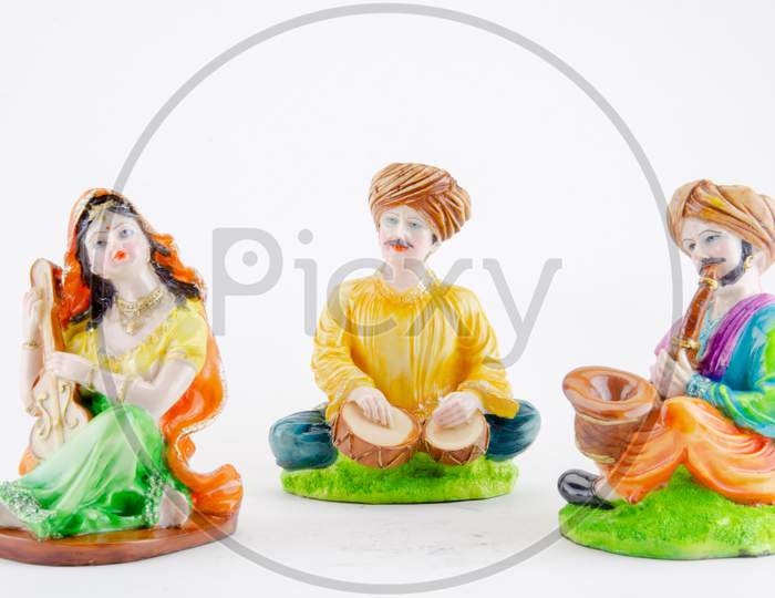 Action Figures Or Toys  Of Indian Traditional  Musicians Playing Instruments Over An Isolated White Background