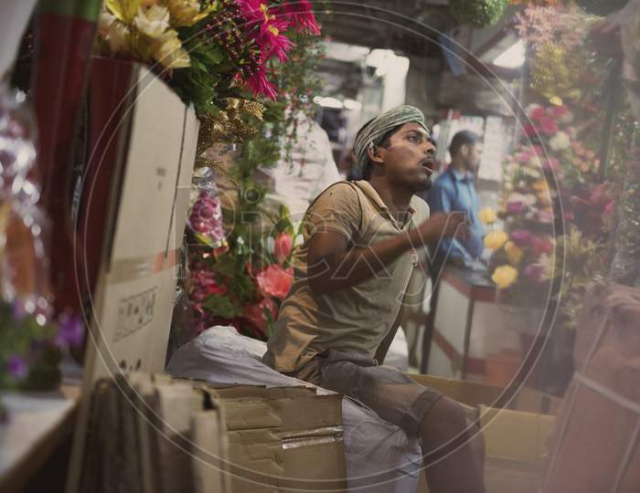Indian worker man sitting in the flower stall