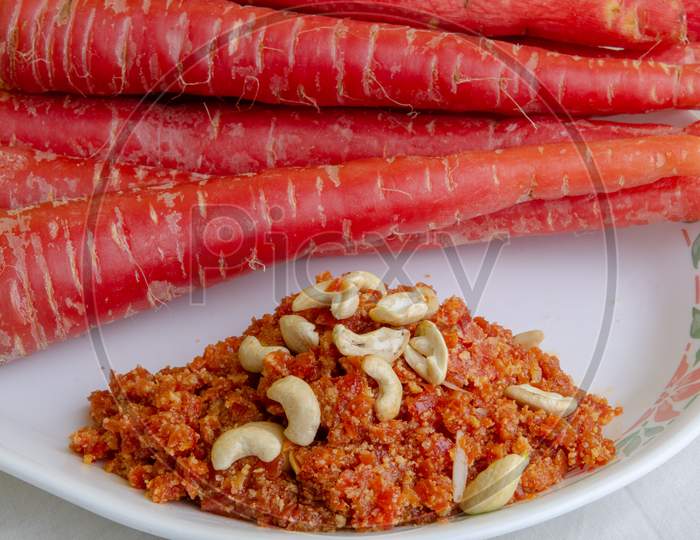Carrot Halwa   Served in Plate With Fresh Carrots  Over White Background