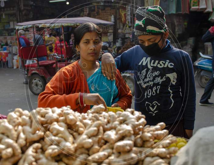 An Indian Woman Buying Ginger From A Vendor Stall At a   Market