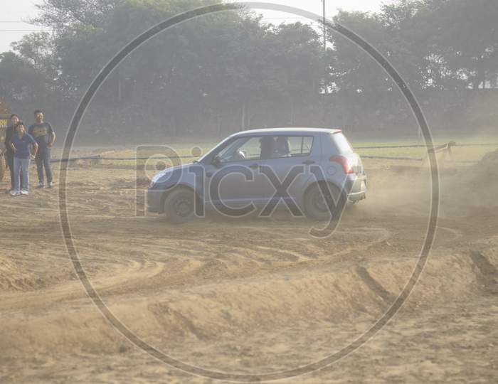 View of Maruti Suzuki Swift taking a turn in the mud road