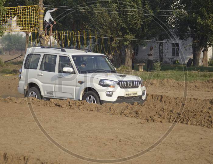 A SUV Car moving along the dirt road