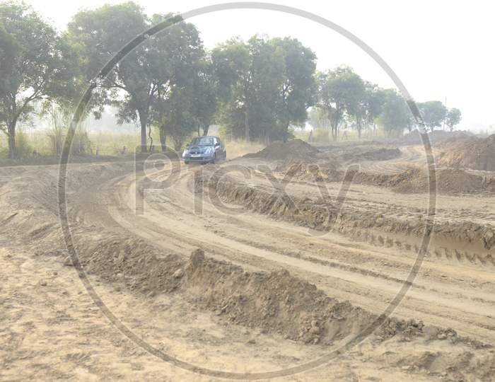 View of Maruti Suzuki Swift moving along the dirt road