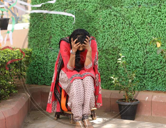 Stressed Indian Girl Sitting By Holding her Head