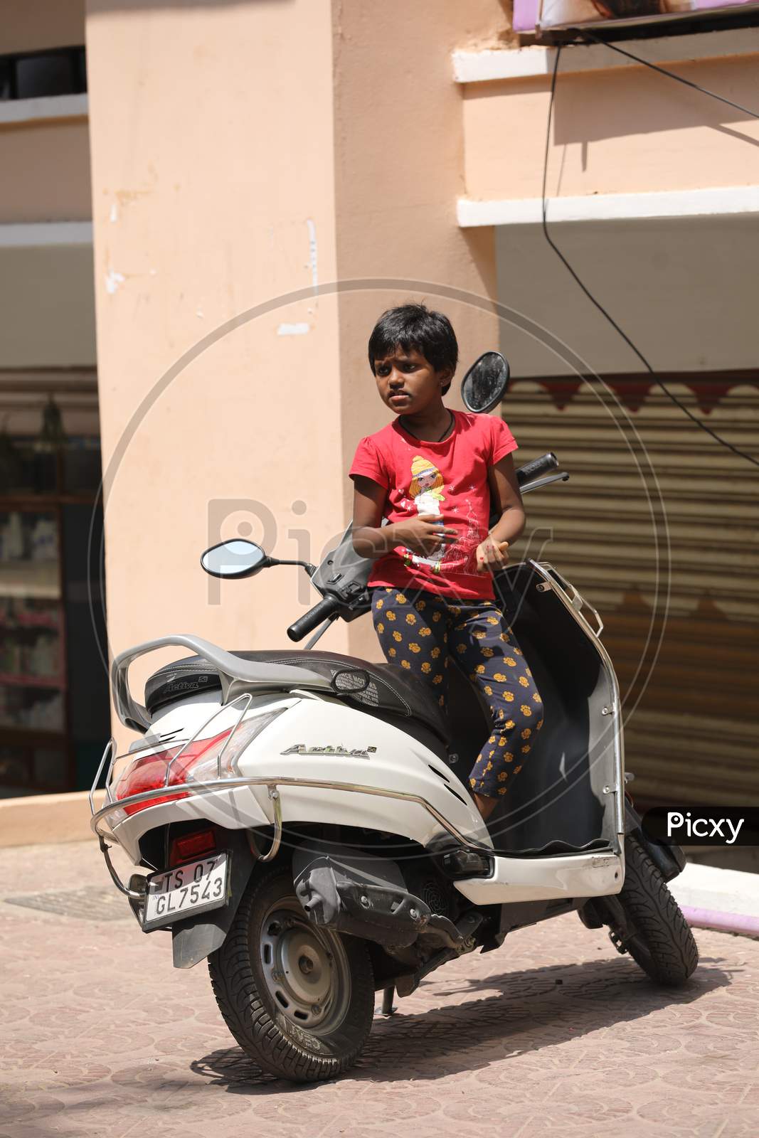 Indian Girl Child Standing on a Scooty
