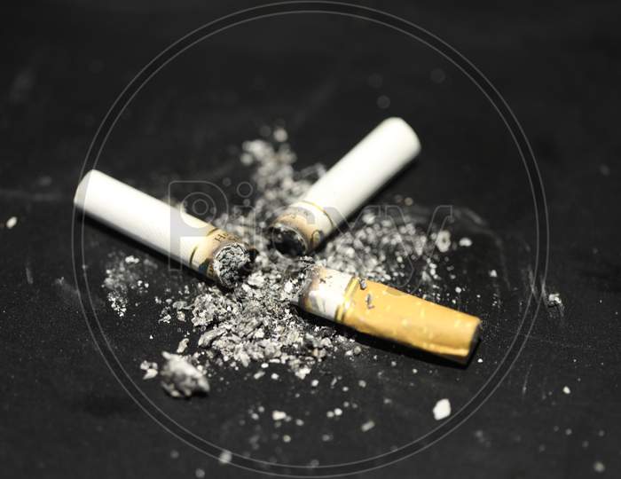 Cigarette Bud With Ash Over an Isolated Black Background , Smoking Kills  And Anti Smoking Concept