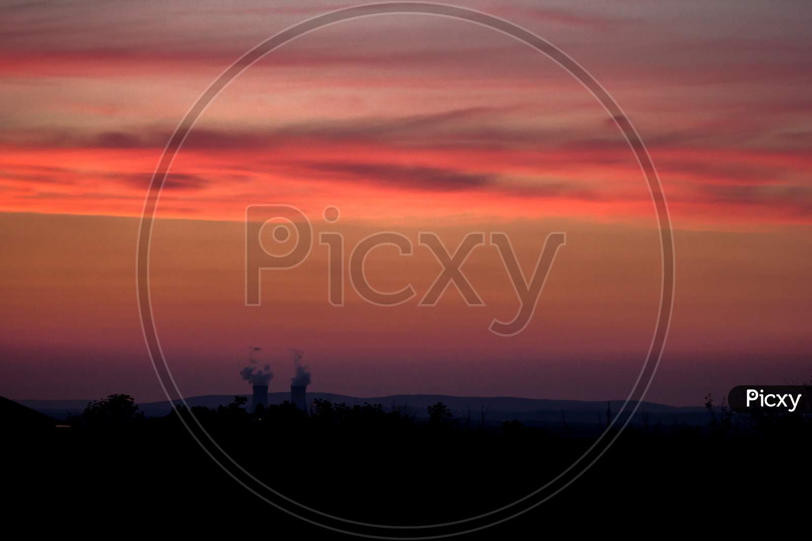 Red Sunset Sky With An Industrial Hover Pipe With Smoke Coming
