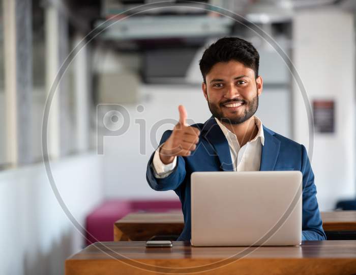 Successful Indian Businessman Using Laptop At an Office Desk