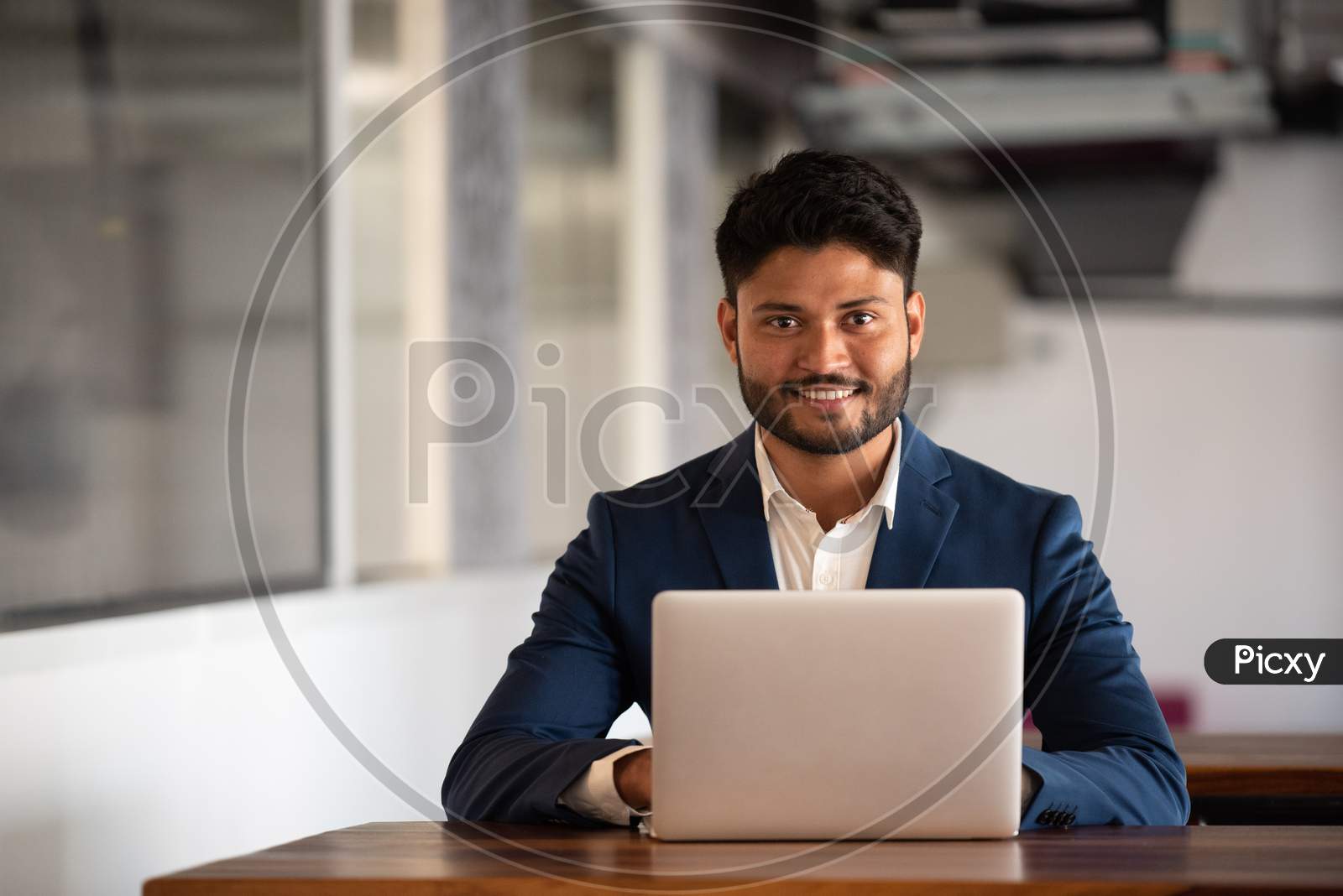 Indian  Businessman Using  Laptop at an Office  Desk