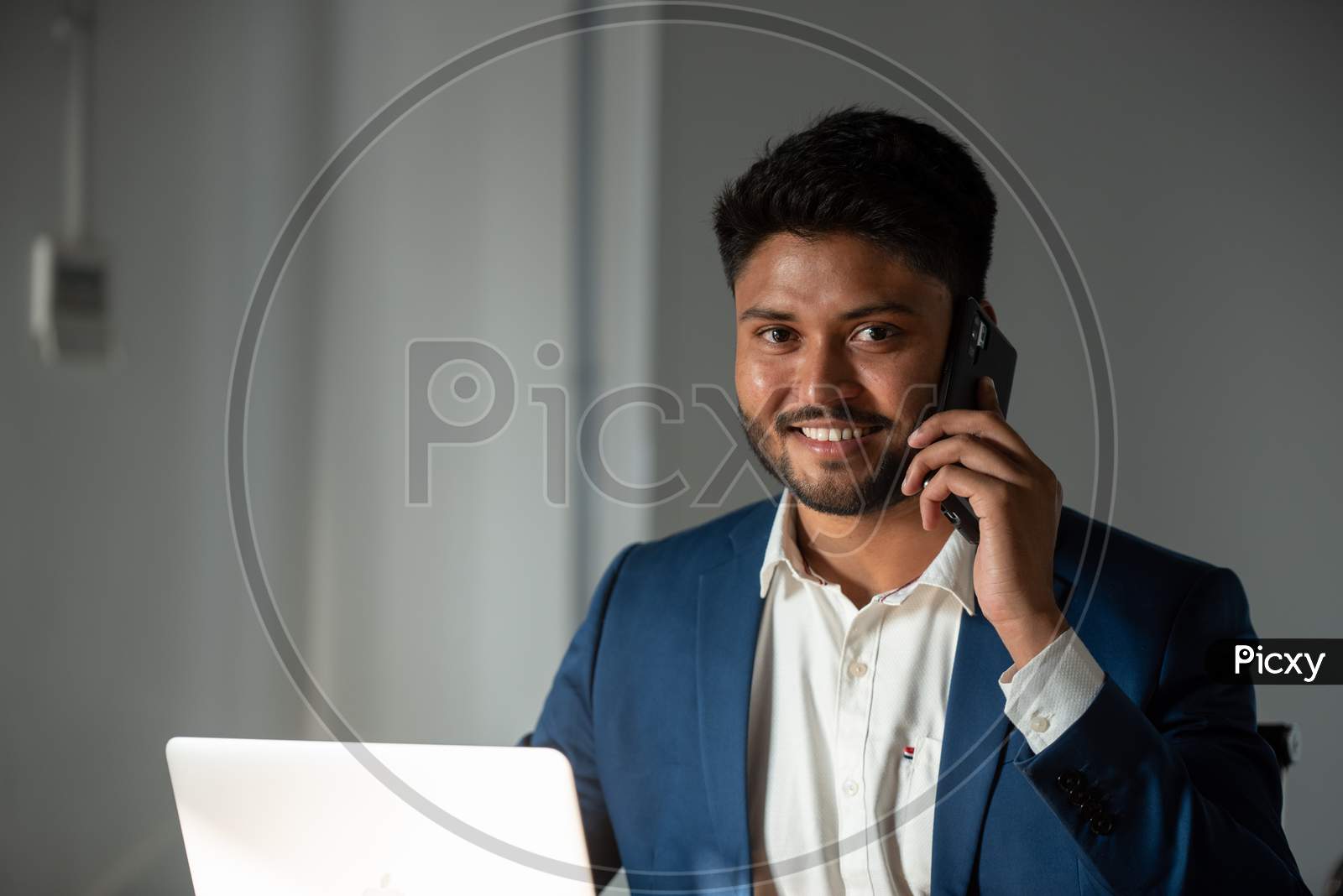 Indian Businessman Speaking In  Smartphone At Office desk  Background