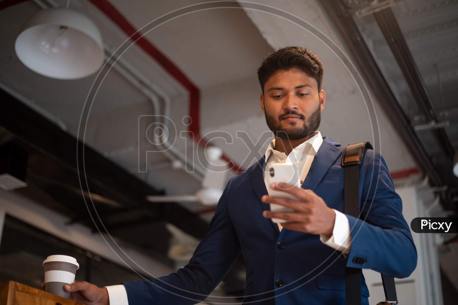 Indian Young Businessman Holding Coffee Cup at An Office