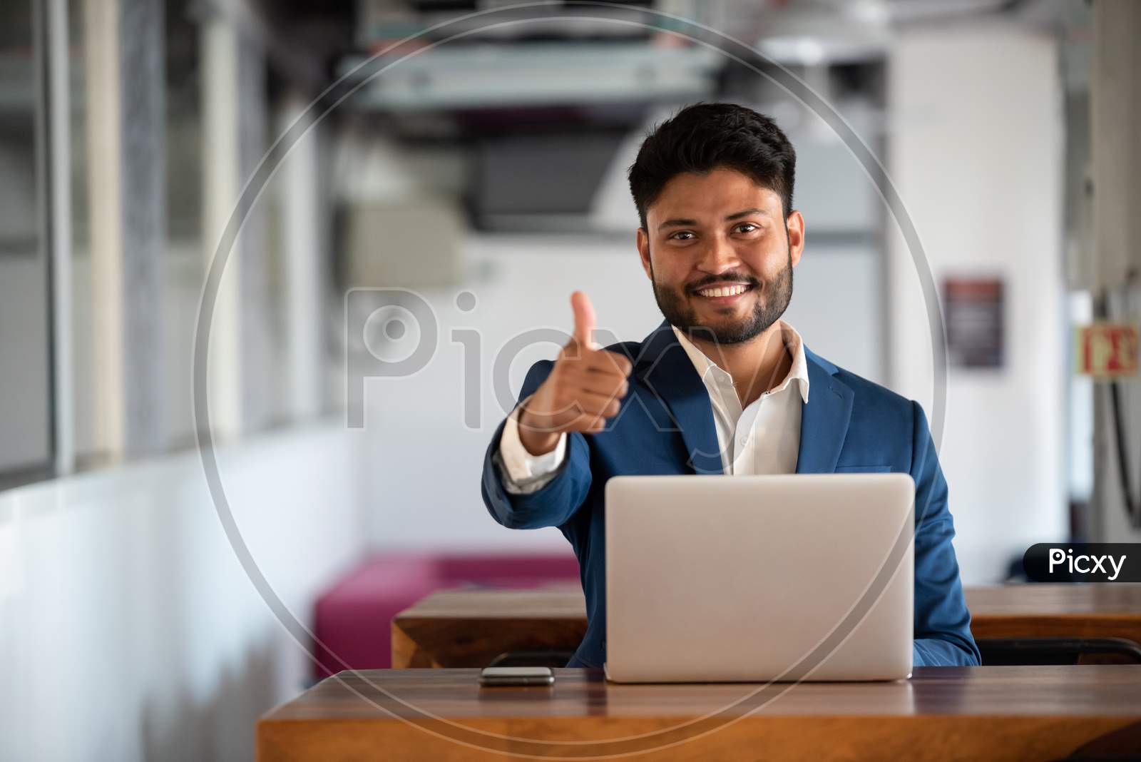 Successful Indian Businessman Using Laptop At an Office Desk