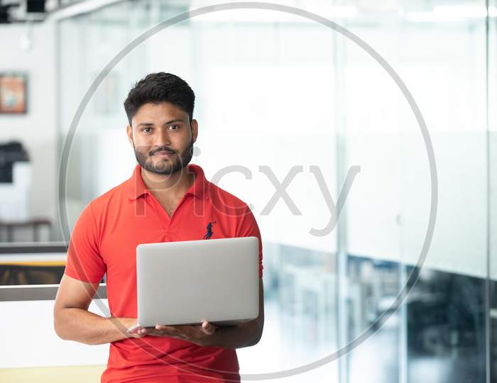 Indian Young Smiling  Businessman Working With Laptop In an Office  Indoor Background
