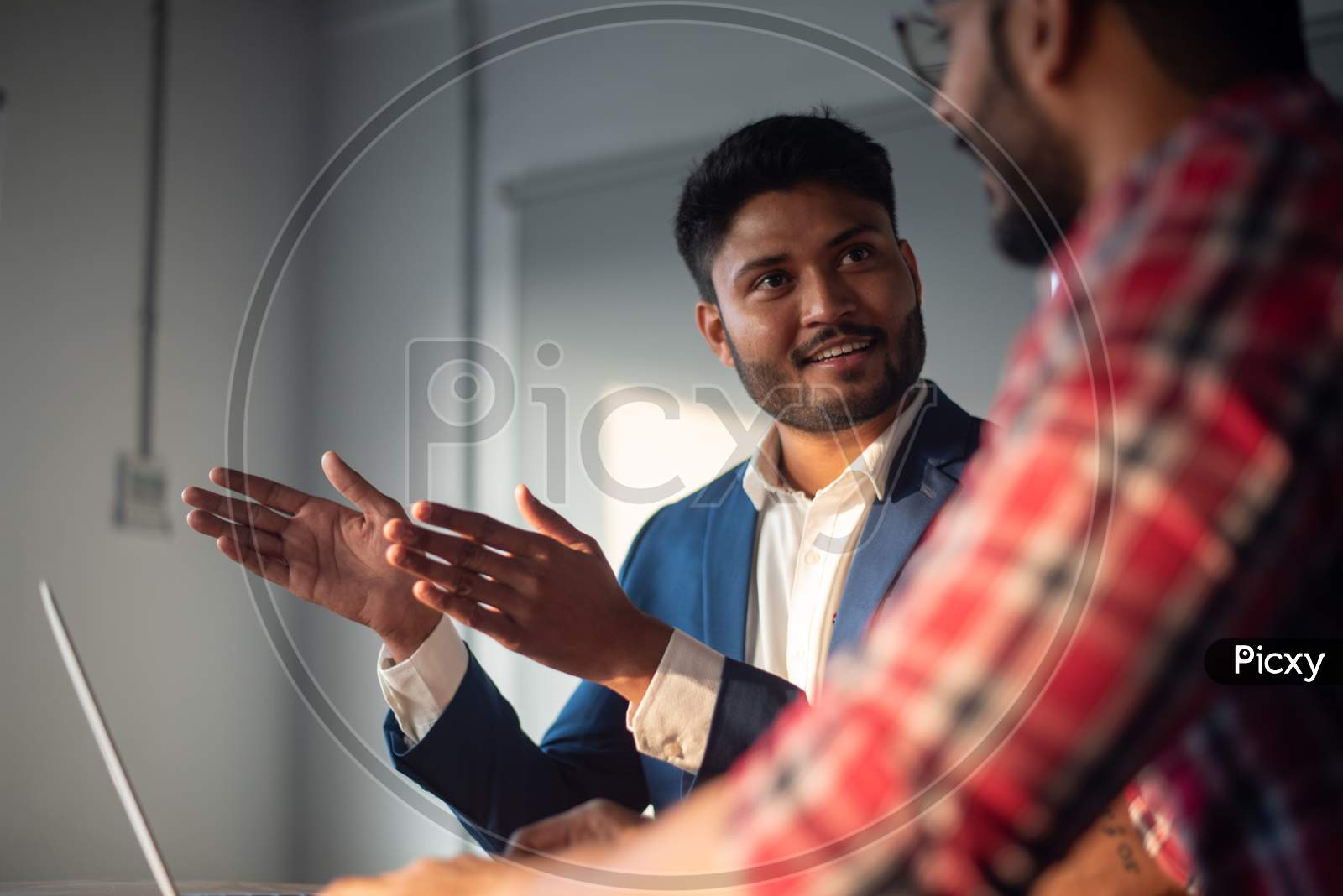 Indian Businessman Discussing Strategies With Colleague