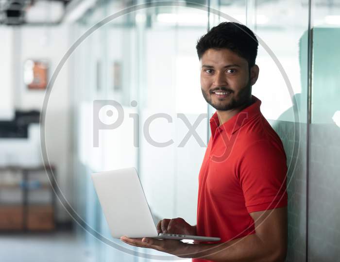 Indian Male Student Using Laptop With Smile Face