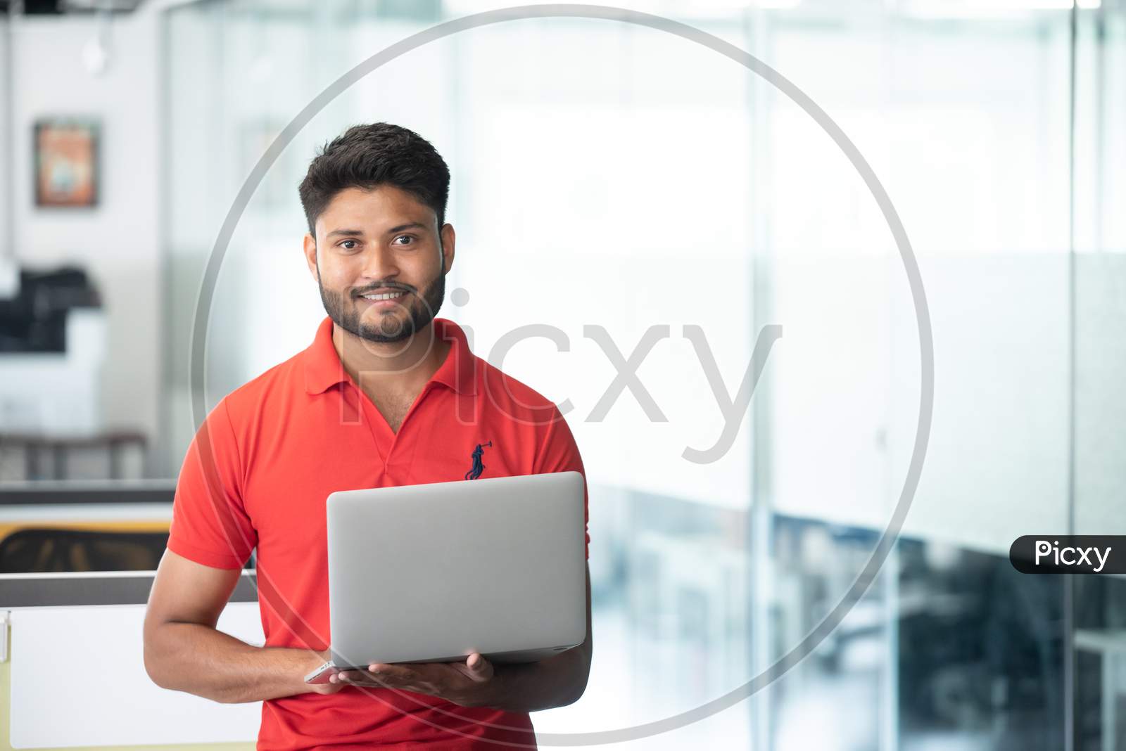 Indian Young Smiling  Businessman Working With Laptop In an Office  Indoor Background