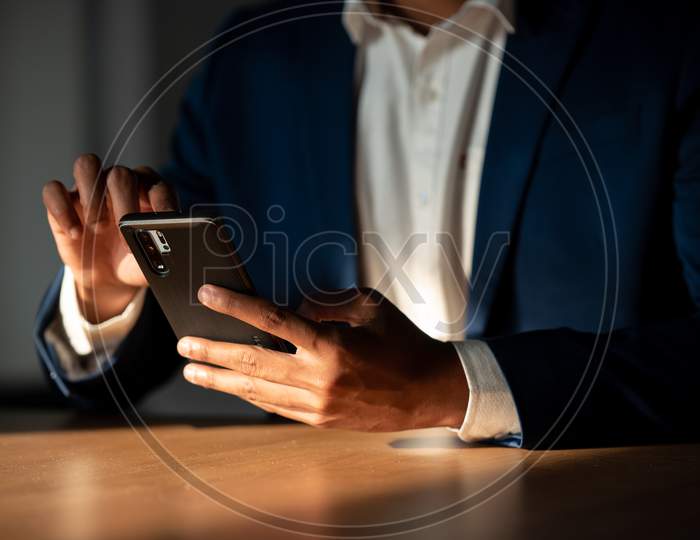 Indian Businessman Using Smartphone At Office desk  Background