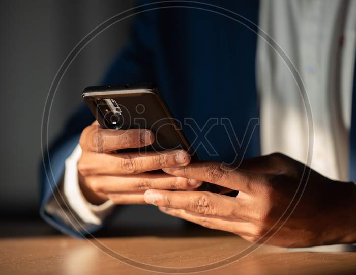 Indian Businessman Using Smartphone At Office desk  Background