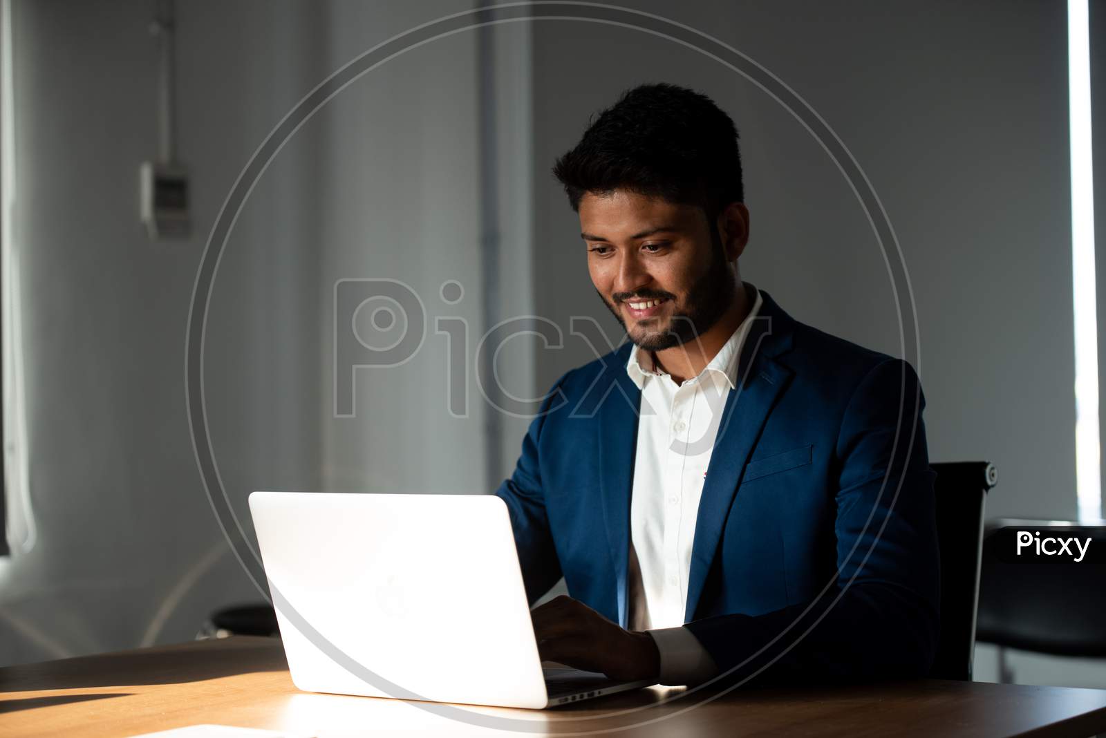 Indian Businessman Using Laptop At an Office Desk