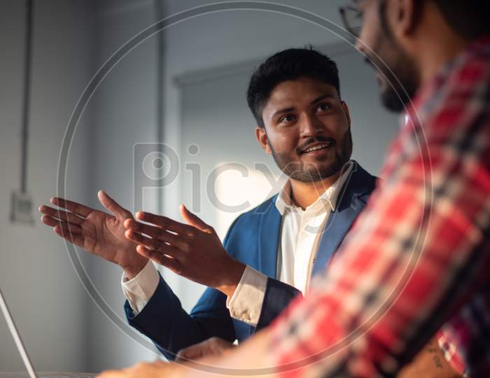 Indian Businessman Discussing Strategies With Colleague