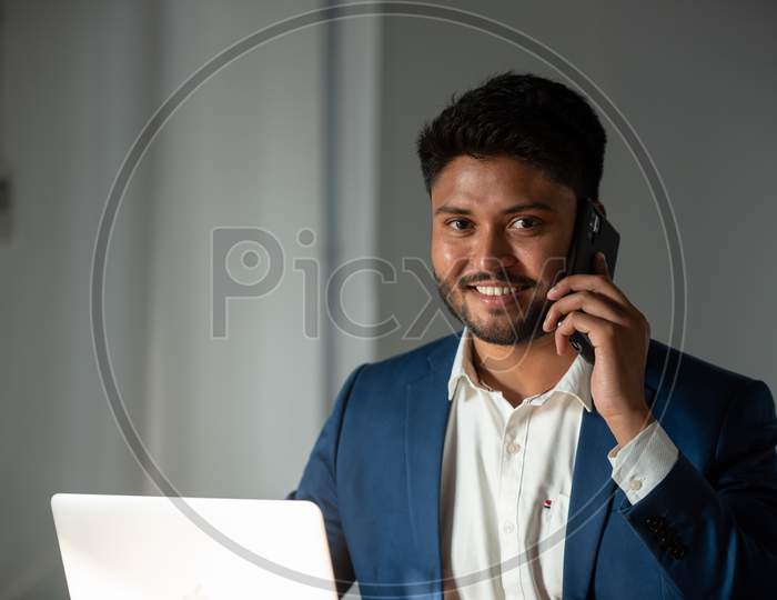 Indian Businessman Speaking In  Smartphone At Office desk  Background