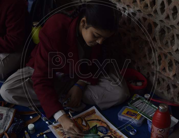 Indian school girl painting during a competition